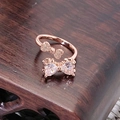 Detailansicht eines roségoldenen Rings mit Doppelbogendesign und Herz-Zirkonia-Steinen - Doppelte Schleife mit Herz-Edelstein Stil (JZ3210A)