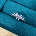 Macro shot of a silver bow ring with pink pear-shaped stones in a dark velvet box - Adjustable Open / Sweet Bowknot Style (JZ4366)