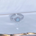 Dettaglio anello fiore in zircone azzurro con castone argento su vassoio ceramica - Aperto Regolabile / Stile Halo Floreale con Pietra Celeste Rotonda (JZ0538A)