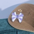 Dettaglio anello fiocco in smalto viola con zircone su sacchetto di velluto marrone - Fiocco a Righe Viola Centro Zirconia (JZ2620)
