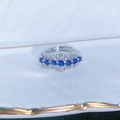 Vista macro di un anello regolabile in argento con sette pietre blu e dettagli zirconi - Aperto Regolabile / Stile Svuotato Vintage con Sette Pietre Blu Rotonde (JZ4810)