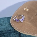 Macro dettaglio dell'anello a farfalla in argento con smalto viola su sfondo di velluto - Doppia Farfalla Viola Asimmetrica (JZ5868)