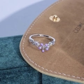 Dettaglio anello fiore smalto viola con zirconi su sfondo di velluto verde - Fiore a Cinque Petali Viola Diamante (JZ6209)