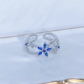 Macro shot of silver floral ring with marquise-cut blue gems and white zircon inlay - Adjustable Open / Six-petal Flower Blue Gemstone Style (JZ5850)