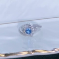 Dettaglio macro di anello regolabile in argento con gemma blu e pavé di zirconi - Aperto Regolabile / Stile Fiocco di Neve Stellato e Pietra Blu Rotonda (JZ6269)