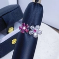 Makroaufnahme des Doppelblumenrings mit rosa und weißen Edelsteinen auf Lederhalter - Einstellbar Offen / Rosa Weiß Kontrast Doppelblume Stil (JZ3939)