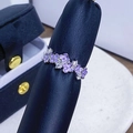 Nahaufnahme des violetten Emaille-Blumenrings mit weißen Zirkonia auf Leder-Display - Einstellbar Offen / Lila Emaille Vier-Blütenblatt Reihenring Stil (JZ6211)