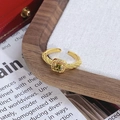 Gros plan d'une bague dorée vintage avec pierre verte carrée et texture dépolie - Style Pierre Gemme Verte Carrée (JZ2216A)