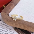 Gros plan d'une bague dorée avec fleur en émail blanc, perles et détails en zircon - Style Fleur à Cinq Pétales Blanche Perle (JZ4746A)