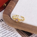 Détail d'une bague dorée vintage avec gemme violette sur fond d'exposition élégant - Style Étoile Pierre Gemme Violette Ronde (JZ6058)