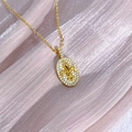 Detailansicht einer goldenen Iris-Halskette mit Zirkonia auf rosa gefaltetem Hintergrund - Fleur-de-Lis Anhänger Halskette (JZ2760A) / Gold