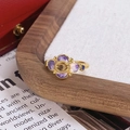 Gros plan d'une bague fleur vintage avec émail violet, ambre et finition dorée - Style Trèfle Dégradé Violet (JZ6088)
