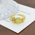 Detail eines Vintage-Goldblumenrings mit grünem Katzenaugenstein und Kordelband - Hellgrüner Katzenauge Blumen-Stil (JZ1677A)
