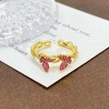 Detalle de anillo vintage dorado con dijes de mariposa rosa y textura de banda trenzada - Estilo Doble Mariposa Rosa (JZ1791A)
