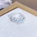 Dettaglio anello a farfalla in smalto blu con accenti di zircone su velluto bianco - Stile Gruppo di Farfalle Blu Chiaro (JZ2090A)