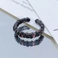 Detail eines gotischen schwarzen Dornenrings mit rotem Edelstein auf Spiegeloberfläche - Einstellbar Offen / Dunkle Dornen Rubin-Stil (JZ1180A)