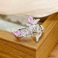 Close-up of a silver open ring with pink marquise-cut zircon and white crystals on wood - Flower Butterfly Duo Style (JZ4368)