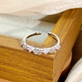 Detailed shot of a silver ring featuring rose motifs and pink stones on a wooden stand - Rose Flower Inlaid Style (JZ4646A)
