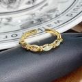 Makro-Detail des Vintage-Goldrings mit grünen Steinen und funkelnden weißen Zirkonia - Olivgrüne Dekoration Vintage Gold (JZ2995A)