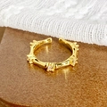 Détail macro d'une bague style bambou dorée avec zircons sur un fond en bois rustique - Ouvert Réglable / Style Ornement Zirconium en Forme de Bambou (JZ6290)