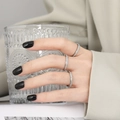 Lot de trois bagues minimalistes en titane argenté mat portées par un mannequin chic - US 5 / Acier