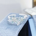 Gros plan d'une bague avec fleurs en émail bleu et pierres en zircone étincelantes - Style Fleur Dégradé Bleu Ciel (JZ3340A)