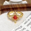 Gros plan d'une bague vintage dorée avec gemme orange et zircons blancs étincelants - Bague Fleur de Soleil Pierre Orange (JZ3039A)