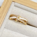 Nahaufnahme des vergoldeten Emaille-Bogenrings mit Zirkonia-Pavé in einer Schmuckbox - Weiße Emaille Goldtöne Kreuzender Stil (JZ5411)