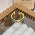Close-up of vintage floral enamel ring on velvet tray with colorful botanical textures - Adjustable Open / Blue Green Orange Floral Enamel Style (JZ6117)