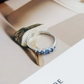 Detail view of adjustable silver ring with five round blue zircons in prong setting - Adjustable Open / Five-Stone Sea Blue Zircon Style (JZ0492A)