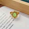 Détail macro d'une bague dorée vintage avec gemme verte et texture gaufrée - Ouvert Réglable / Style Base Carrée Gemme Verte Ovale (JZ3956)