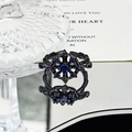 Macro shot of a dark punk ring with a blue crystal center and snowflake metal engraving - Dark Blue Round Starburst Style (JZ4131)
