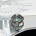 Macro shot of gothic ring featuring sky blue gemstone and black gold dragon scale carving - Blue Stone Winged Planet Style (JZ5878)