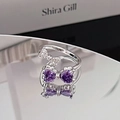 Macro shot of a silver bow open ring with purple heart-shaped cubic zirconia and clear stones - Double Purple Heart Bowknot Style (JZ0511A)