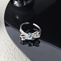 Detailed macro view of silver bow ring with blue oval gemstone on black reflective surface - Light Blue Oval Zircon Bowknot Style (JZ5645)