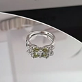 Macro detail of silver bow ring featuring olive green heart stones and white zircons - Olive Green Heart Zircon Bowknot Style (JZ5695)