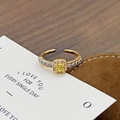 Makroaufnahme Goldring mit quadratischem gelbem Zirkon auf Sentiment-Geschenkkarte - Einstellbar Offen / Quadratischer Halo Exquisiter Stil (JZ5812)