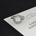 Detail eines silbernen geflochtenen Rings mit Mondstein und feinen Zirkon-Akzenten - Blumen Twist Stil (JZ1201)