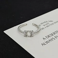 Close-up of silver twist band ring with oval zircon and side stones on aesthetic background - Twist Oval Style (JZ5382A)
