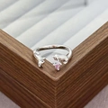 Detail of silver puppy ring with a pink heart zircon on a wooden jewelry box edge - Interactive Puppies Style (JZ0820A)