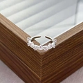 Close-up of adjustable silver ring with pink zircon stones on a wooden jewelry box - Wave Petal Style (JZ0825A)