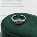 Makroaufnahme eines lila Halo-Rings mit Silberband und weißen Zirkonia auf Samt - Einstellbar Offen / Paariger Runder Halo-Stil (JZ0081A)