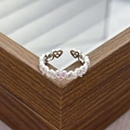 Close-up of adjustable silver heart ring with sparkling pink zircons on wood box - Continuous Hearts Pink Gem Style (JZ2852A)
