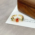 Detail of vintage gold open ring featuring oval orange zircon and green gemstones - Three-Color Gemstone Claw Setting(JZ3212A)
