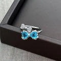 Detail shot of a silver bow ring featuring blue heart-shaped gems and micro-set zircons - Adjustable Open / Double Bowknot Heart Blue Stone (JZ0273A)