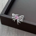 Macro view of silver bow ring with pink heart-shaped zircon on a dark stone surface - Adjustable Open / Pink Heart Gemstone Style (JZ2774)