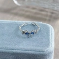 Nahaufnahme eines silbernen Schmetterlingsrings mit blauen Zirkoniasteinen auf Samt - Einstellbar Offen / Blauer Schleifenstil (JZ0186A)