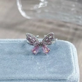 Detailed macro shot of a butterfly ring with pink gemstones on a light blue velvet box - Adjustable Open / Pink Gem-Look Butterfly Style (JZ3990A)