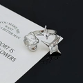 Detailaufnahme des silbernen Sternrings mit Zirkonia-Steinen auf schwarzem Glasgrund - Runddiamant Doppelter Vierpunktstern Stil (JZ0274)