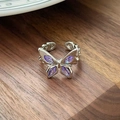 Detailansicht eines Schmetterlingsrings mit lila Zirkon auf dunklem Walnussholz - Marquise Schmetterling Zirkonia Stil(JZ0853)